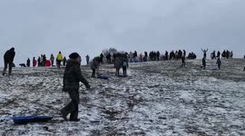 Lack of social distancing as snow falls and sledges come out in London
