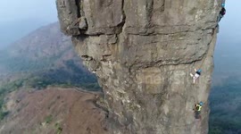 Group of people climb Indian rock formation to mark death anniversary of folk hero