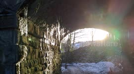 Storm Darcy foot long icicles hanging from an old railway incline bridge in freezing cold weather, Wirksworth, Derbyshire Dales, UK
