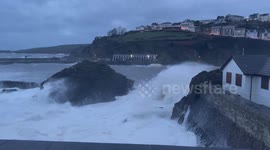 Dangerously high waves crash over seawall of village in Cornwall, UK
