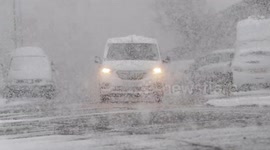 Traffic contends with a heavy snow shower in Sheerness, Kent, UK