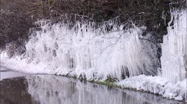 Stunning icicle hedge reflected in water in Kent, UK