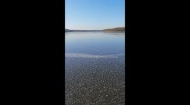 Stone skipping on a frozen lake, with surprising sounds coming up from it