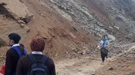 Locals dodge landslide as they cross blocked highway in northern India