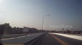 A car pulls out suddenly into traffic and crosses a road almost causing an accident.