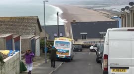 Ice cream seller does good business in 2 degrees Centigrade, as snow starts to fall. Southern end of Chesil Beach, Fortuneswell, Isle of Portland, UK