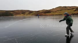 Ice skaters make most of frozen lake in England's picturesque Lake District