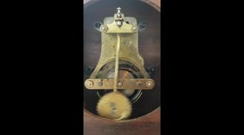 Ticking mechanical clock showing the mainspring and bob.