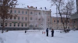 Brigade of snow shovelers clear snowdrifts of a roof in central Moscow amid heavy snowfall