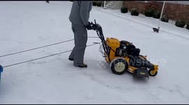 Pulling young girl riding in bucket with lawnmower
