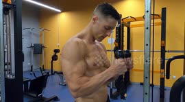 Muscular guy doing hammer curl exercise with rope in the gym