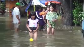 Mother washes clothes in the house when the floods enter the house of Central Jakarta, Indonesia