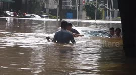 Roadside team shifts submerged cars out of flooded neighbourhood in Indonesia