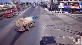 Truck tips over after trying to avoid scooter running red light in China