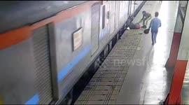 Woman saved after being dragged by moving train in India
