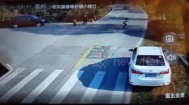 Car narrowly misses schoolboy running across road in China