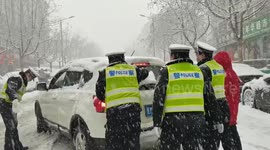 Police officers rescue vehicles stranded on snow-covered road in northern China