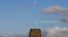 Full snow moon rising over an ancient disused windmill & a wind turbine, Carsington Pasture, Near Wirksworth, Derbyshire, England, UK