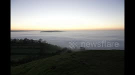 Spectacular sunrise and swirling mists viewed from on top of the Glastonbury Tor
