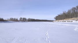 Snowmobile Pass By on Red River south of Winnipeg, Manitoba, Canada
