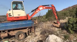 Digger driver perfectly levers his vehicle off trailer using crane power