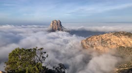 Incredible waves of mist surfing in the Mediterranean Sea on the island of es Vedrá.