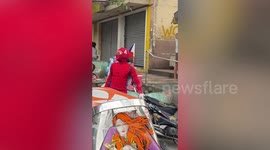 Man in Spider-Man suit carries grocery bags on the way home