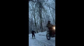 Skier towed by motorbike around the town