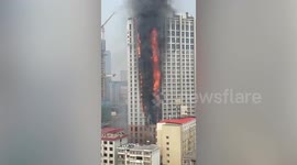 Chinese firefighters battle to extinguish high-rise building engulfed in flames