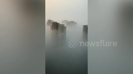 High-rise buildings poke out from blanket of fog shrouding city in north China