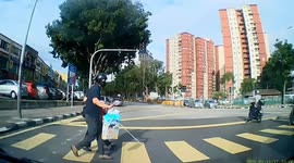 Kind motorcyclist stops to help blind woman cross road in Malaysia