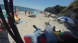 Paraglider crashes into sunbathers on beach