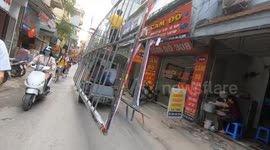 Circus show tricycle! Ludicrous tricycle carrying giant iron frames across the narrow streets of Vietnam