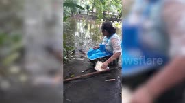 Fearless Thai woman feeds crocodiles as she sits just inches away from them