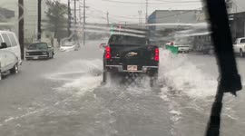 Vehicles struggle to pass through submerged roads as flood warnings remain in Hawaii, US