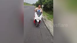 Cute pet dog rides pillion on owner’s motorcycle in Thailand