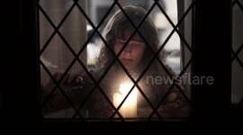 A young woman lights a candle in memory of Sarah Everard