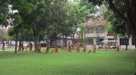 A group of novice Buddhist monks do some spring cleaning at a temple at in Thailand.