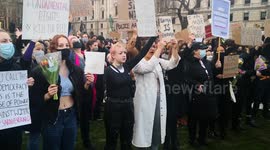 Women hold signs at Kill the Bill protest at Parliament Square in London