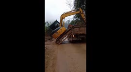 Skilled excavator operator manages to manoeuvre vehicle onto truck in dangerous stunt