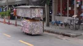 Vendor on a motor tricycle in Bangkok selling stickers,dolls and ceramic items