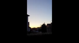 flock of over 50 geese flyover English village while honking noisily