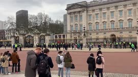 Police officers stand in front of Buckingham palace amongst lockdown protest in london