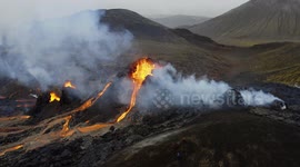 Hikers watch streams of lava spurted from Iceland volcano flow past