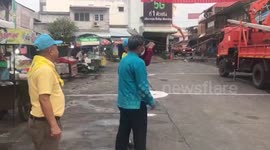 Summer storm blows over five electricity posts blocking road in Thailand