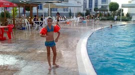 Acrobatic feat or somersault (flip or salto) by a small girl into the pool