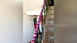 Elderly Chinese woman puts wool knitted covers on railing to warm residents' hands