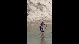 Aussie woman effortlessly carries snake across creek after nonchalantly wrapping reptile around her neck