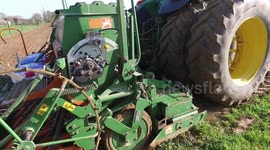From standing still a tractor and sowing drill unit set off to plant the final run of Flax, or Linseed in a northern French field