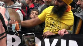 Man falsely claims  'vaccine genocide' while burning masked Boris Johnson cutout at London rally